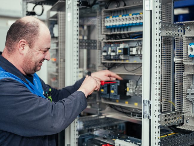 Elektriker arbeitet an Schaltschrank von Henkelhausen